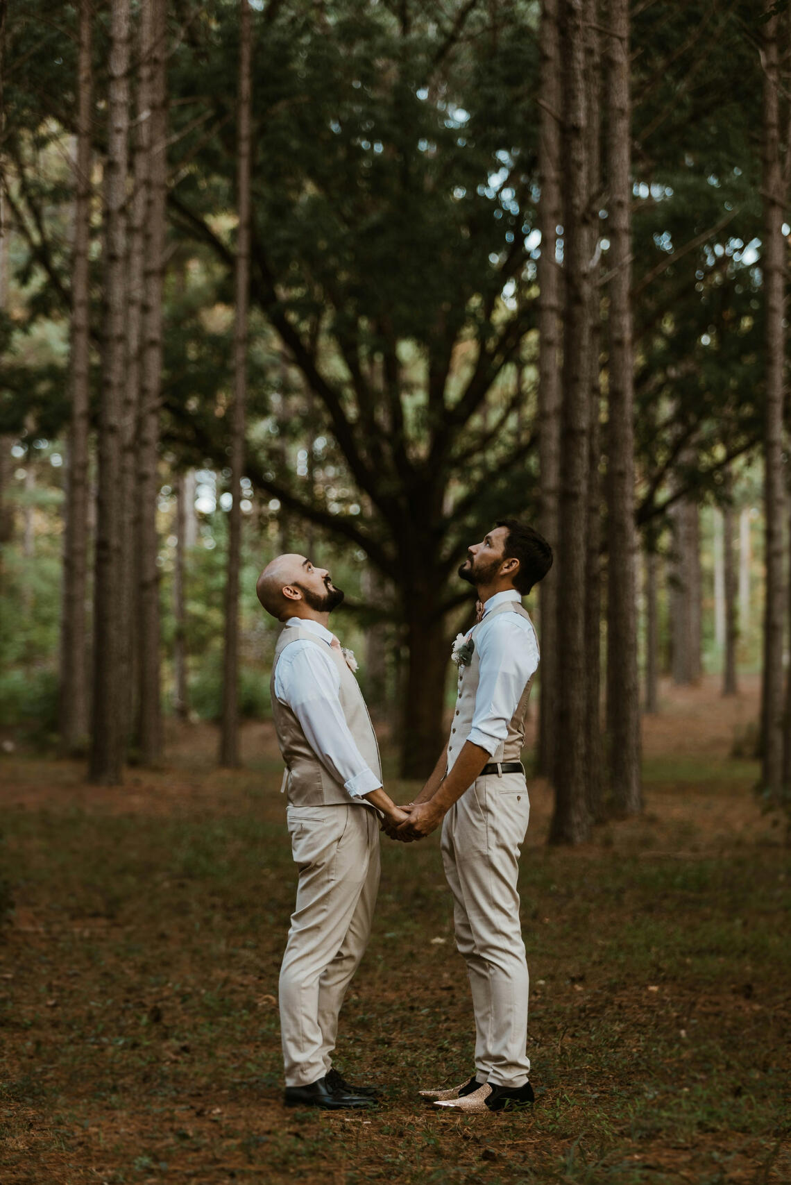 Photo by Brandy Wine on Unsplash Two men standing in a forest holding hands looking up